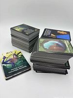 Three stacks of Magic: The Gathering cards including promo insert and token card
