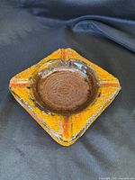 top view of orange square ashtray, showing interior brown glaze and corner rests