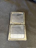 Compact mirror opened showing two square mirrors inside