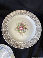 Scalloped plate with pink rose centre and black scroll border