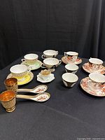 Overview of assorted tea cups, saucers, goblets and spoons