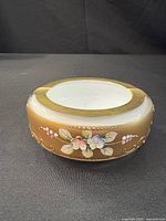 Side view showing gold gilt exterior and enamel floral decoration