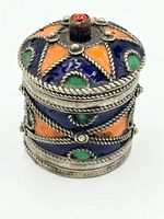 Closed cylindrical pill box showing enamel panels and rope trim