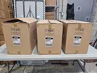 Three sealed cardboard cartons on table