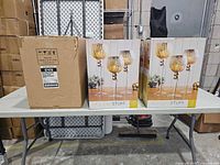 Master carton and two retail boxes of Holiday Stuff candle holder sets on table