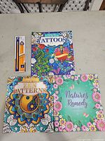 Front view of three coloring books and pencil pack