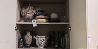 Cabinet shelves showing full lot including vases, planter and pot bases