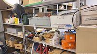 Shelves with assorted hardware, electrical boxes, safety switch, axle stands visible
