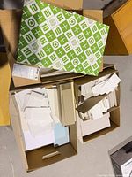 Three cardboard boxes with assorted blank paper sheets and envelopes