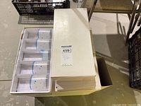 Stacked boxed sets with open box showing five glass compartments