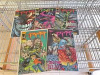 Five Pitt comics laid out on wire shelf