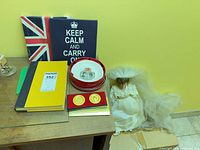 Lot overview showing canvases, dish with tin, medals, books, doll partly visible