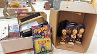 Overview showing boxes of trading cards, five NHL bobbleheads, and sealed Six-Arm Spider-Man figure
