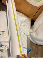Rolled white felt sheet with measuring tape showing length