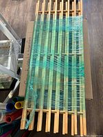 Top view of bundled slatted wooden shoe rack wrapped in plastic