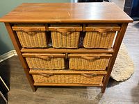 Front view of wood cabinet with all six wicker baskets inserted