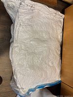 Vacuum-sealed clear plastic bag containing compressed white pillows