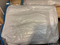 Vacuum-sealed clear bag containing white quilt batting