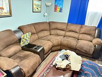 Full view of brown microfiber sectional sofa with faux leather trim and center console