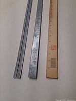 Three cleats beside wooden ruler for scale