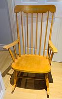 Front view of wooden rocking chair showing seat, spindles and runners
