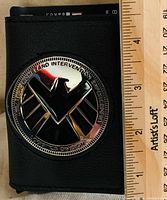 Front of wallet showing metal SHIELD emblem and scale with ruler