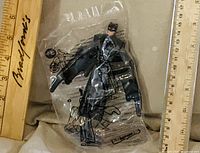 Front view of sealed Batman action figure with rulers for scale