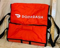 Front view showing DoorDash logo, straps and scale rulers