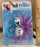 Front view of sealed Olaf bag clip on Frozen blister card with ruler for scale