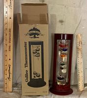 Thermometer and box beside rulers for scale
