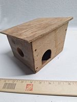 Overall view of wooden pet house with ruler for scale