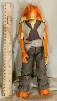 Front view of Jar Jar Binks figure beside ruler