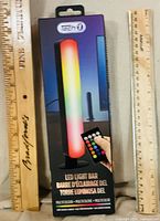 Retail-boxed Tech 1 LED light bar showing product image and remote, rulers for scale