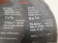 Close-up of specification text on two discs (7 in × 1/8 in and 9 in × 1/4 in)