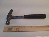 Full view of hammer alongside ruler for scale