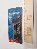 Front of sealed Mastercraft 3-inch line level package beside ruler for scale