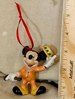 Front view of Mickey Mouse ornament beside ruler showing height