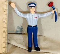 Front view of Mr. Rooter figurine beside ruler showing approx 5 in height