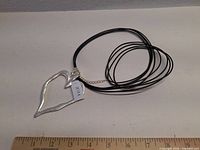 Necklace coiled showing heart pendant, clasp, price tag