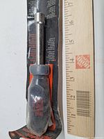 Front view of Popular Mechanics 7/16 in. nut driver on retail card with ruler for scale