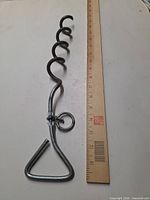 Full view of steel spiral ground stake beside ruler showing length