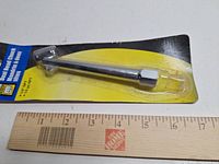 Front view of packaged PowerFist dual head air chuck next to ruler showing size
