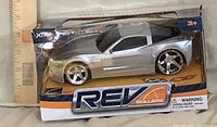 Packaged REV Rollers silver toy car with ruler for scale