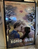 Framed Romeo + Juliet poster leaning against wall with tape measure showing height