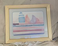 Front view of framed pastel sailboat print showing image, mat and gold frame