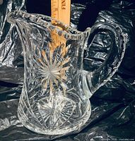 Full view of crystal pitcher showing design and size reference with ruler