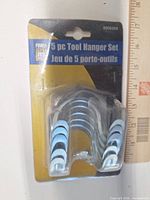 Front of sealed package showing five metal hangers and product card