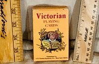 Front of Victorian Playing Cards tuck box beside rulers for scale