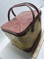 Overall view of the plaid metal picnic basket showing lid, handles, pattern and scale with ruler