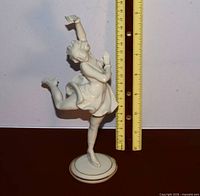 Front view of porcelain skater with ruler showing height